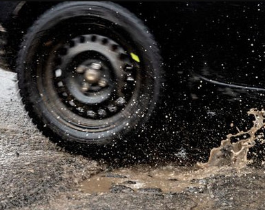 Picture of a tyre splashing through a pothole